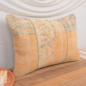 May include: A yellow and cream throw pillow with a vintage floral pattern. The pillow is made from a soft, woven fabric and has a fringed edge.
