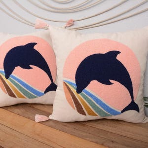 Funda de almohada bordada con delfines: cojín con diseño de atardecer en el océano y borlas rosas, decoración costera de verano.