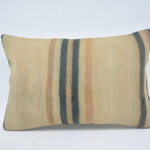 May include: A beige throw pillow with dark blue and light pink stripes. The pillow is made of a woven fabric and has a rectangular shape.