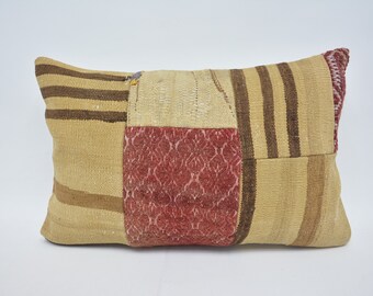 May include: A rectangular patchwork pillow with a brown, beige, and red color scheme. The pillow is made of woven fabric and has a variety of patterns, including stripes and floral designs.