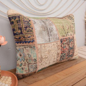 May include: A patchwork pillow cover with a variety of colors and patterns, including blue, green, and beige. The pillow cover is made from a soft, woven fabric and has a fringed edge.