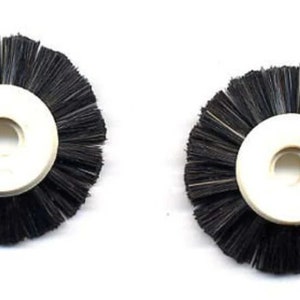 May include: Two black round brushes with white plastic centers. The brushes have a ring in the center of the plastic.
