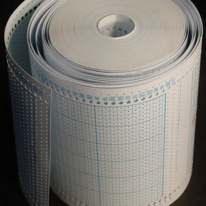 May include: A rolled-up reel of white computer paper, showing perforated edges and a grid pattern. The paper is tightly wound, revealing the inner core. The edges have evenly spaced holes, and the surface features light blue grid lines and numbers.