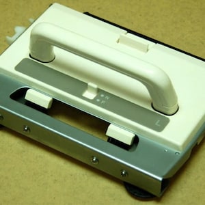 May include: A white knitting machine with a handle and a metal base. The machine has a switch labeled "ON" and "OFF" and a lever labeled "L".