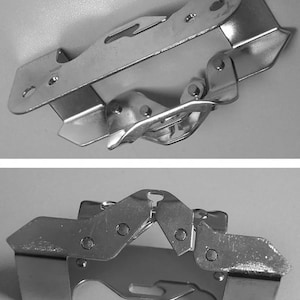 May include: Two views of a silver-colored metal hinge. The hinge has a complex design with multiple pivoting sections, rivets, and cut-out shapes. The metal has a shiny, reflective surface.