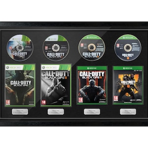 Può includere: Una cornice nera che contiene quattro dischi e quattro custodie del videogioco "Call of Duty: Black Ops". I dischi e le custodie sono disposti a griglia, con i titoli e i loghi del gioco visibili.