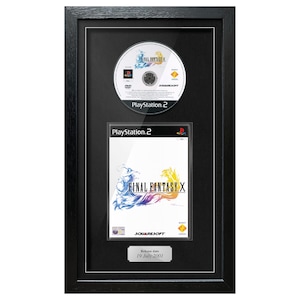 May include: Framed Final Fantasy X PlayStation 2 game and disc. The game case and disc are displayed in a black frame. The game case features the game title and artwork. The disc has the game title and PlayStation 2 logo.