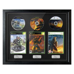 Peut inclure: Cadre noir présentant trois disques et boîtiers de jeux vidéo Halo. Le cadre contient les disques et boîtiers de jeux Xbox et Xbox 360 originaux. Les boîtiers de jeux indiquent les dates de sortie de novembre 2001, novembre 2004 et septembre 2007.