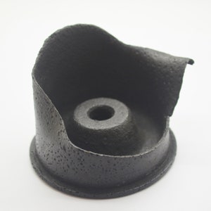 Puede incluir: Soporte de motor de goma negro con una superficie texturizada y un agujero central.