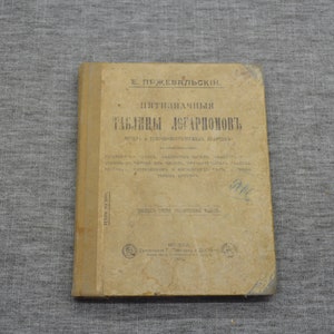 Puede incluir: Un libro antiguo titulado "Nitiznachnyia Tablitsy Logarinov" de E. Przheval'skii. El libro está encuadernado en papel marrón con una lomo amarillo. El texto de la portada está en ruso.
