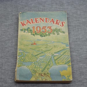 May include: A vintage calendar from 1953 with the word "KALENDARS" printed in red and yellow letters. The cover features a colorful illustration of a landscape with a small red building.