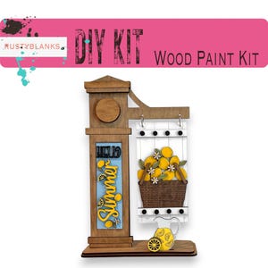 May include: A DIY wood paint kit featuring a vertical sign post with the text "HELLO SUMMER" in yellow and blue, alongside a hanging white rectangular board displaying a brown basket filled with yellow lemons and white flowers, plus a pitcher.