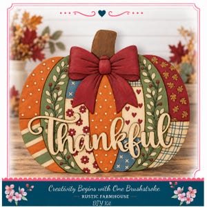 May include: A decorative wooden pumpkin cutout featuring a patchwork design of orange, green, blue, and red patterns with a large red bow at the top. The word Thankful is written in a light-colored script font across the center of the pumpkin.