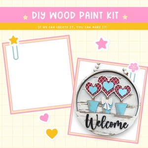 May include: DIY wood paint kit featuring a round wooden sign with a distressed white finish. The sign has three blue flower pots with red hearts and blue hearts on top. The sign says "Welcome" in black lettering.