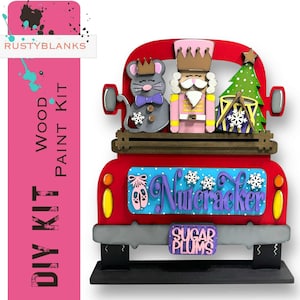 May include: A red wooden DIY paint kit shaped like a truck, featuring a mouse, nutcracker, and Christmas tree. The truck bed has the word "Nutcracker" and "Sugar Plums". The kit includes the text "DIY KIT" and "WOOD PAINT KIT".