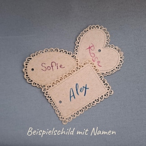 May include: Three decorative paper tags with scalloped edges. The tags are oval, heart-shaped, and rectangular. The oval tag says "Sofie", the heart-shaped tag says "Rose", and the rectangular tag says "Alex".