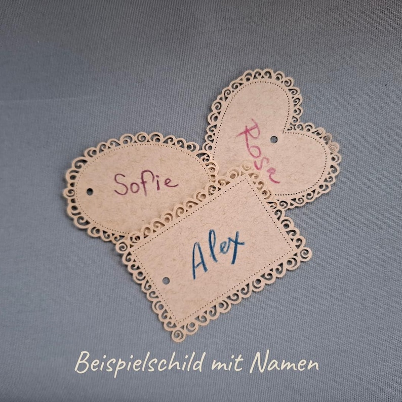 May include: Three decorative paper tags with scalloped edges. The tags are oval, heart-shaped, and rectangular. The oval tag says "Sofie", the heart-shaped tag says "Rose", and the rectangular tag says "Alex".