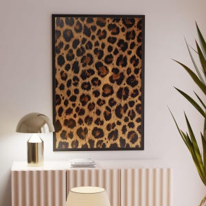May include: A framed print of a leopard print pattern in shades of brown and black.