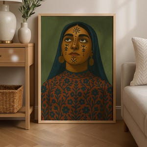 May include: A framed portrait of a person with dark skin, wearing a blue head covering and a rust-colored dress with blue floral patterns. The person has gold earrings and facial markings. The background is a muted green.