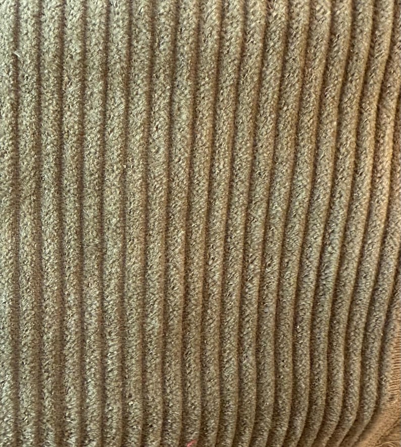 Op de afbeelding: Close-up van een bruine corduroy stof met een verticale ribbelstructuur.