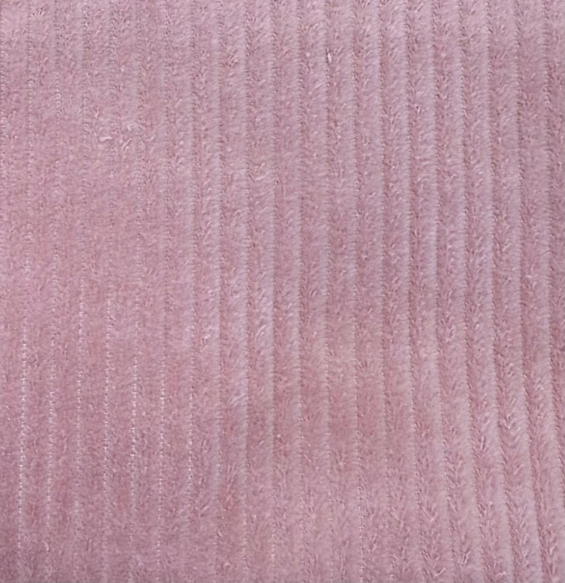 Op de afbeelding: Een close-up van een zachte, roze stof met een verticale ribbelstructuur.