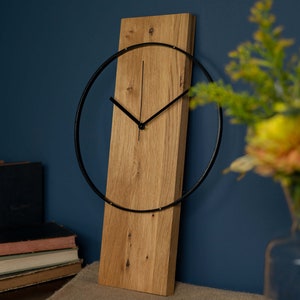 Modern wall clock made of solid wood, oak, minimalist wooden clock with black painted wooden ring