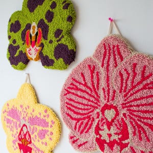 Pode incluir: Tr&ecirc;s tape&ccedil;arias de parede de orqu&iacute;deas texturizadas em tons de verde, amarelo e rosa. A orqu&iacute;dea verde tem manchas roxas. A orqu&iacute;dea amarela tem detalhes rosa. A orqu&iacute;dea rosa tem detalhes vermelhos. Cada pe&ccedil;a est&aacute; pendurada numa parede branca.