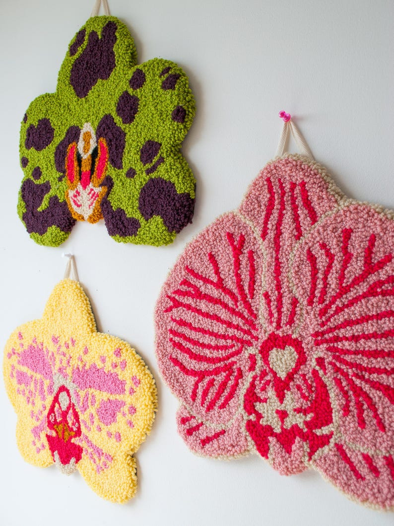 Pode incluir: Tr&ecirc;s tape&ccedil;arias de parede de orqu&iacute;deas texturizadas em tons de verde, amarelo e rosa. A orqu&iacute;dea verde tem manchas roxas. A orqu&iacute;dea amarela tem detalhes rosa. A orqu&iacute;dea rosa tem detalhes vermelhos. Cada pe&ccedil;a est&aacute; pendurada numa parede branca.