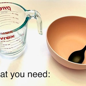 May include: A clear glass measuring cup with red markings and a pink bowl with a black plastic spoon. What you need: