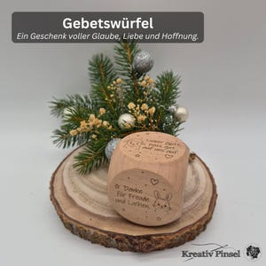 Könnte beinhalten: Ein heller Holzwürfel mit Lasergravuren, darunter ein Schaf mit dem Text 'Lieber Gott, pass gut auf uns auf' und ein Hase mit dem Text 'Danke für Freude und Lachen', verziert mit kleinen Sternen und Herzsymbolen auf den Seiten.