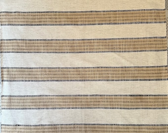 May include: White fabric with brown and black stripes. The fabric has a woven texture.
