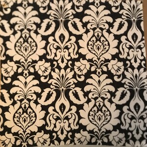 May include: Black and white damask pattern fabric with a repeating design of stylized flowers and leaves.