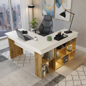 Puede incluir: Escritorio en forma de L blanco y con vetas de madera con estanterías integradas. El escritorio tiene una superficie blanca y patas y estanterías con vetas de madera. Se ve una silla de oficina negra, un portátil y una lámpara de escritorio.