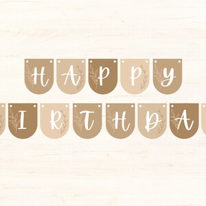 May include: A banner reading "HAPPY BIRTHDAY" in white script on brown and beige pennants. Each pennant features a floral design. The banner is strung on a white string, suitable for a birthday celebration.