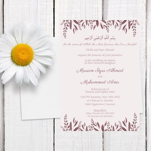 May include: A wedding invitation with floral accents and text in English and Arabic. The invitation features the names of the couple, event details, and RSVP information. A large white daisy with a yellow center is in the upper left corner.