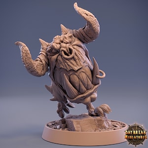 May include: A detailed, unpainted miniature of a fantasy creature with large horns, tusks, and a ring through its nose. The figure stands on a rocky base, with the "Daybreak Miniatures" logo visible on the base.