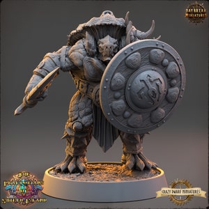 May include: A gray, detailed miniature of a turtle-like creature with a large shield and a spear. The miniature is standing on a round base. The miniature is part of the "The Proto-Torians of Shield Island" game.