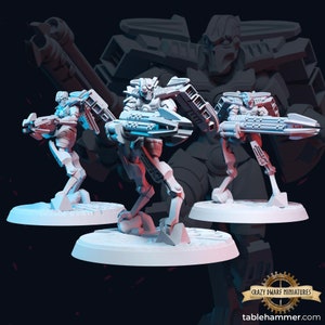 May include: Three gray plastic miniature figures of robots with guns, standing on round bases. The robots are posed in different stances, and each has a different weapon. The figures are part of a set of miniatures for a tabletop game.