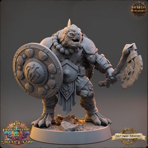May include: A grey painted miniature of a turtle-like creature wearing armor and holding a shield and axe. The miniature is standing on a round base with the text "The Pirate Kings of Shield Island" and "Crazy Dwarf Miniatures" on it.