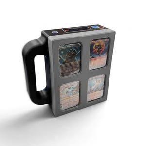 May include: A rectangular gray display case with a black handle, featuring four recessed slots for trading cards. The top surface includes a small digital screen and control buttons. The cards displayed are Leonardo, the Balance, and others.