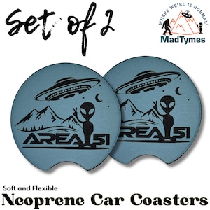 May include: Set of two blue neoprene car coasters with a black alien and UFO graphic. The coasters feature the text "AREA 51" and "WHERE WEIRD IS NORMAL!" with the MadTymes logo.