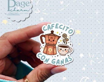 May include: A sticker featuring a brown coffee maker and a smiling coffee cup with the text "Cafecito con Ganas". The sticker has a light blue background with white stars and a logo in the upper left corner.