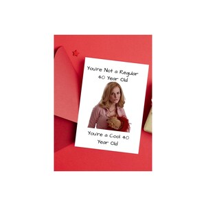 May include: A white card with a photo of a woman holding a stuffed animal. The text on the card reads "You're Not a Regular 40 Year Old. You're a Cool 40 Year Old."