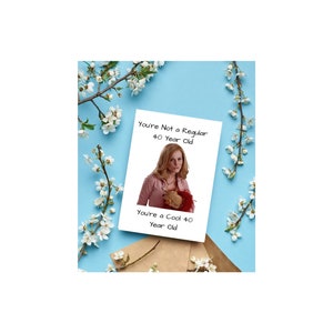 May include: A white card with a picture of a woman holding a stuffed animal. The card says "You're Not a Regular 40 Year Old. You're a Cool 40 Year Old."