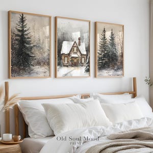 May include: Three framed watercolor paintings depicting a snowy winter scene. The center painting features a small cottage with a snow-covered roof and a pine tree in the foreground. The left and right paintings feature pine trees and a snowy forest.