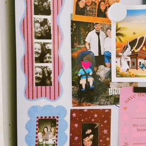 May include: A collection of photographs and cards displayed on a white surface. Items include a vertical photo strip with a pink striped border, a photo of people in a booth, a photo of a person in a stroller, and a pink card with text.