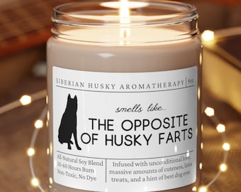 May include: A brown candle with a white label that reads "Siberian Husky Aromatherapy" and "smells like... THE OPPOSITE OF HUSKY FARTS". The label also includes the text "All Natural Soy Blend", "50-40 Hours Burn", "Non-Toxic, No Dye", and "Infused with unconditional love, massive amounts of cuteness, treats, and a hint of best dog ever."