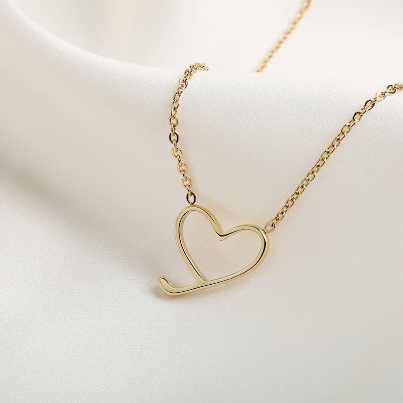 Op de afbeelding: Een gouden ketting met een delicate open hart hanger.