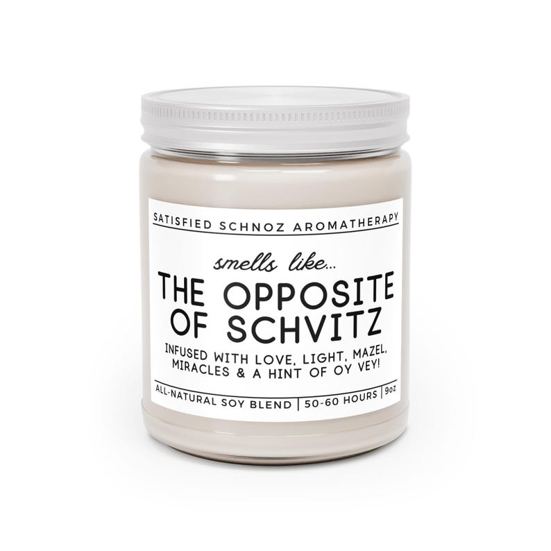 May include: A white candle jar with a silver lid. The label reads "SATISFIED SCHNOZ AROMATHERAPY" and "smells like... THE OPPOSITE OF SCHVITZ". The label also says "INFUSED WITH LOVE, LIGHT, MAZEL, MIRACLES & A HINT OF OY VEY!" and "ALL-NATURAL SOY BLEND | 50-60 HOURS | 9oz".