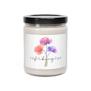 May include: A glass jar candle with a white label and a floral design. The label reads "ref*cking lax" with a watercolor illustration of three flowers in shades of pink, orange, and purple.
